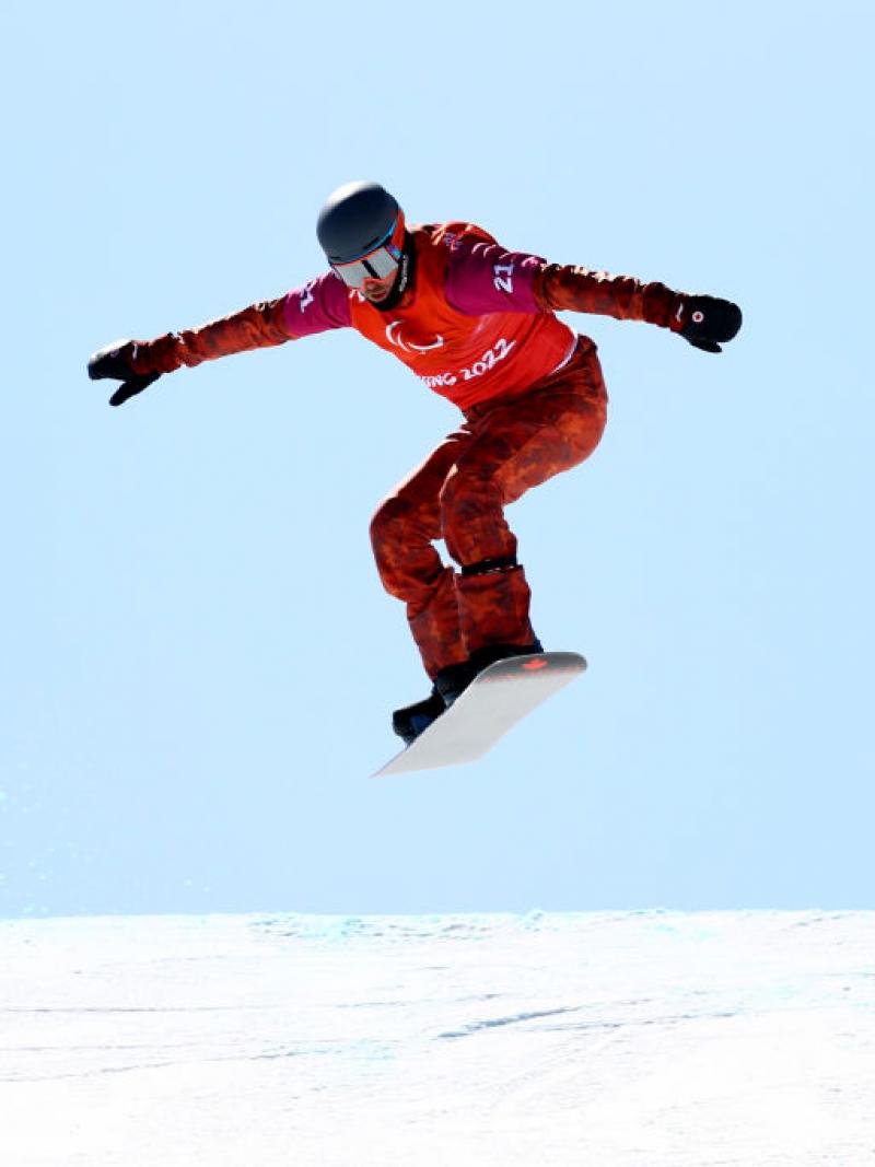 A male Para snowboarder in boardcross competition