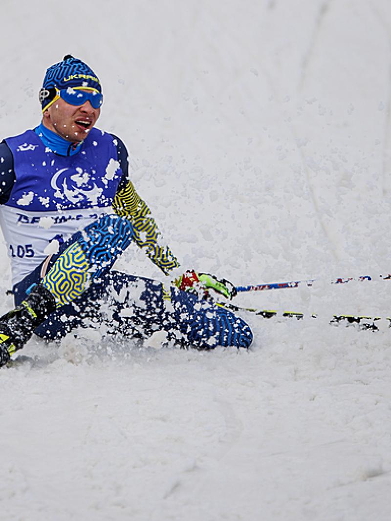 Oleksandr Kazik falls to the ground in a flurry of snow after winning gold at Beijing 2022