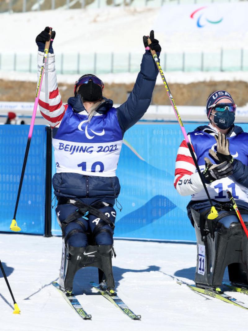Oksana Masters of United States celebrates winning gold with silver medallist Yilin Shan of China and compatriot bronze medallist Kendall Gretsch in the women's Sprint Sitting Para Biathlon on Day One of the Beijing 2022 Paralympics Winter at Zhangjiakou National Biathlon Centre.