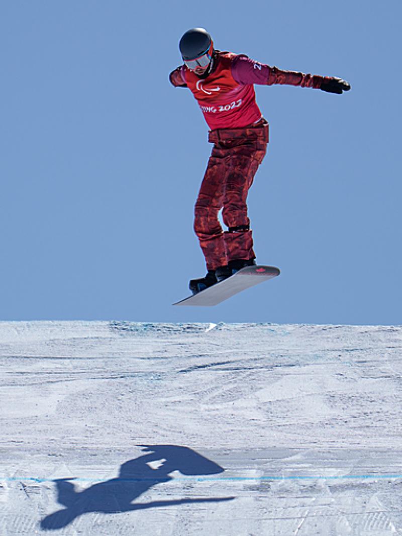 Tyler Turner gets air as he races down the Para snowboard course at Beijing 2022