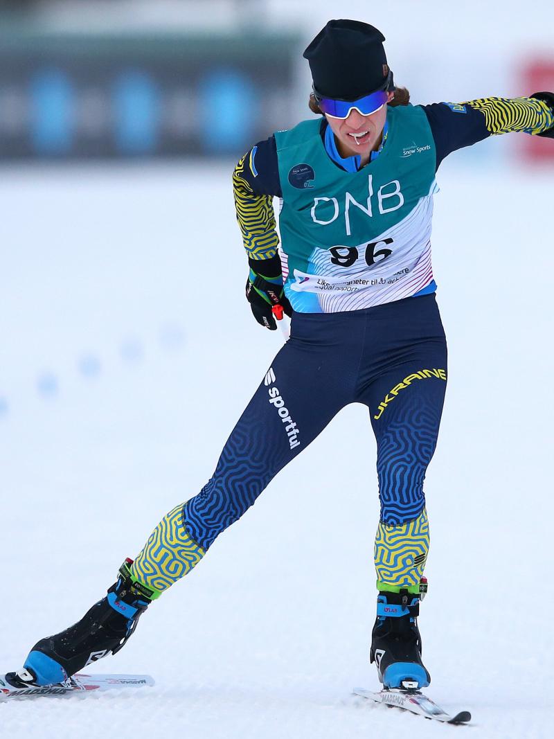 A female athlete ski's on a flat circuit with her goggles on.
