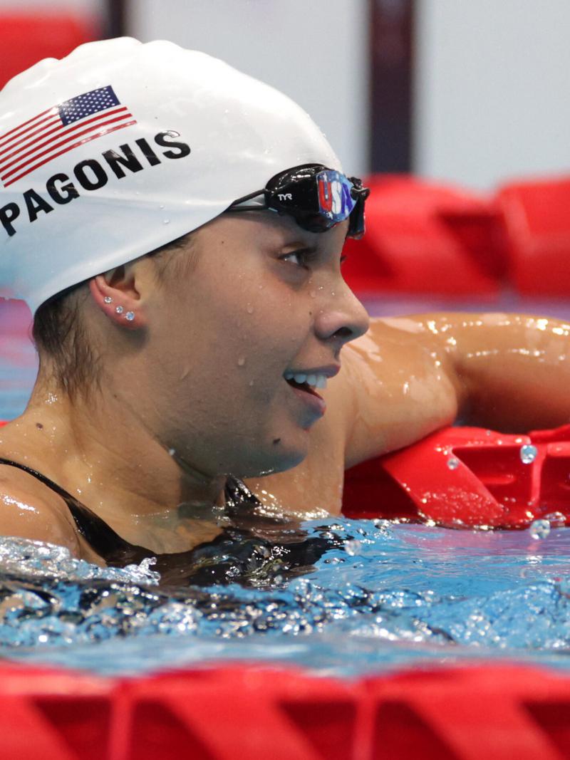 A female Para swimmer hanging on a rope with her left hand and the goggles off.
