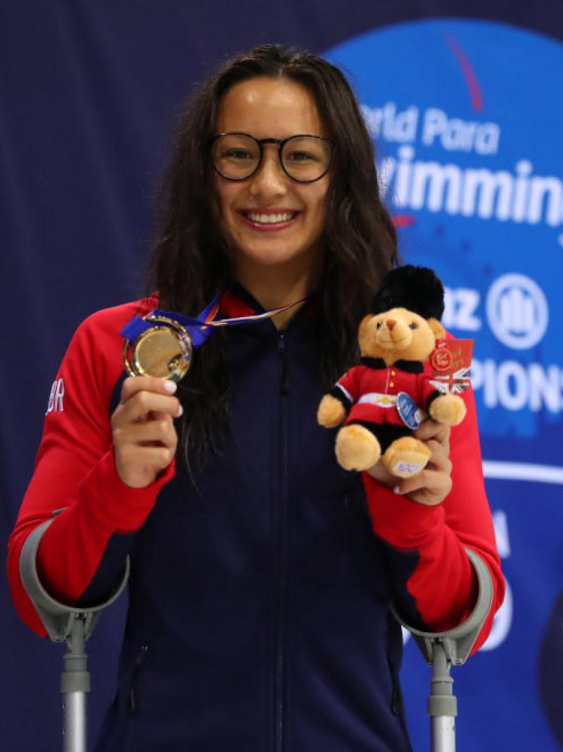 Alice Tai smiles as she holds up a bear mascot and her gold medal from the women's 100m freestyle S8 at the London 2019 World Para Swimming Championships.