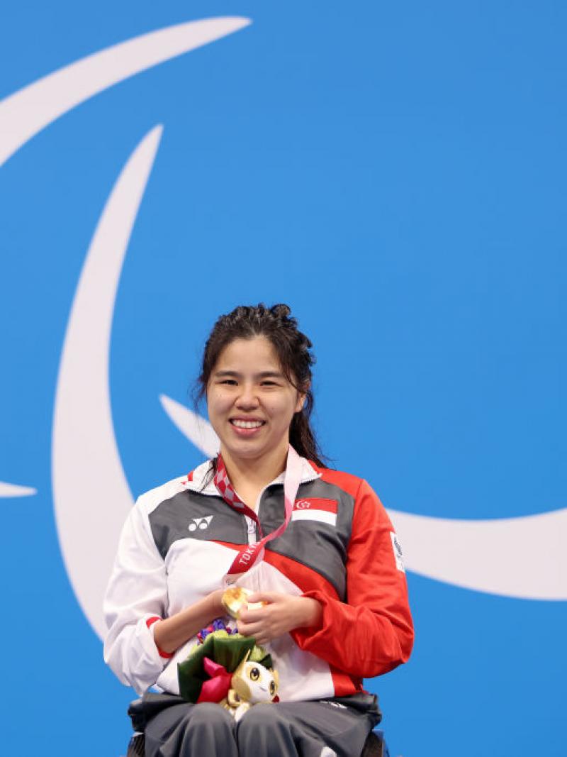 Image of a female para swimmer in the podium after she grabbed gold
