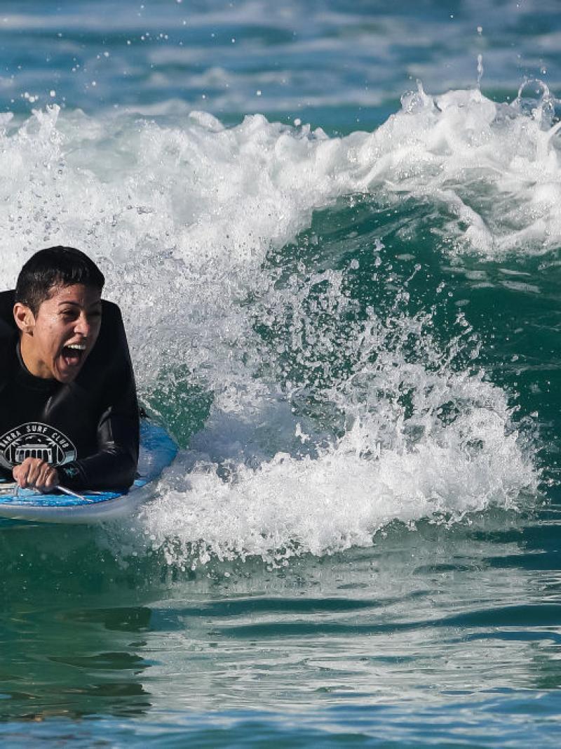 Brazil's Monique Oliveira laughs as she surfs a wave at Barra beach.