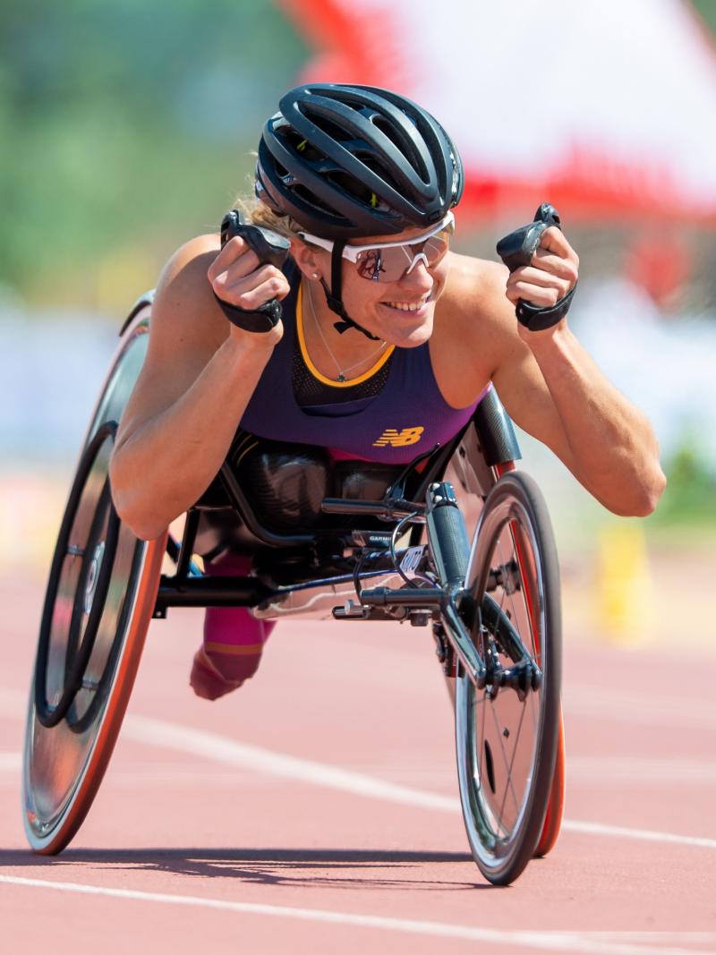 A female wheelchair racer celebrating on an athletics track