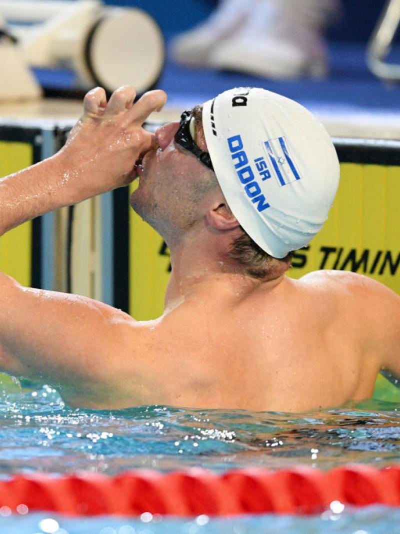 A male swimmer kissing his hand in a pool
