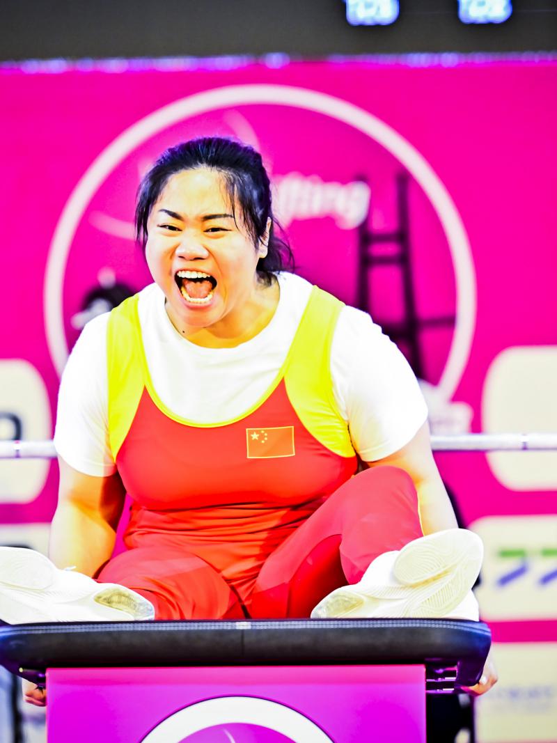 Chinese female Para powerlifter screams in celebration after a successful lift.