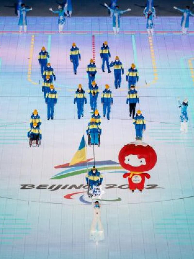 Flagbearer Maksym Yarovyi, a Ukrainian flag attached to his wheelchair, leads the Ukrainian delegation into the Opening Ceremony of the Beijing 2022 Winter Paralympic Games.
