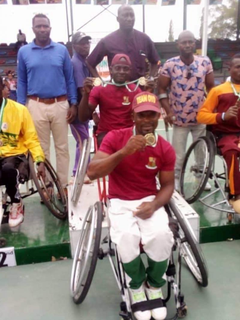 A group of wheelchair tennis players with medals on the podium and next to it.