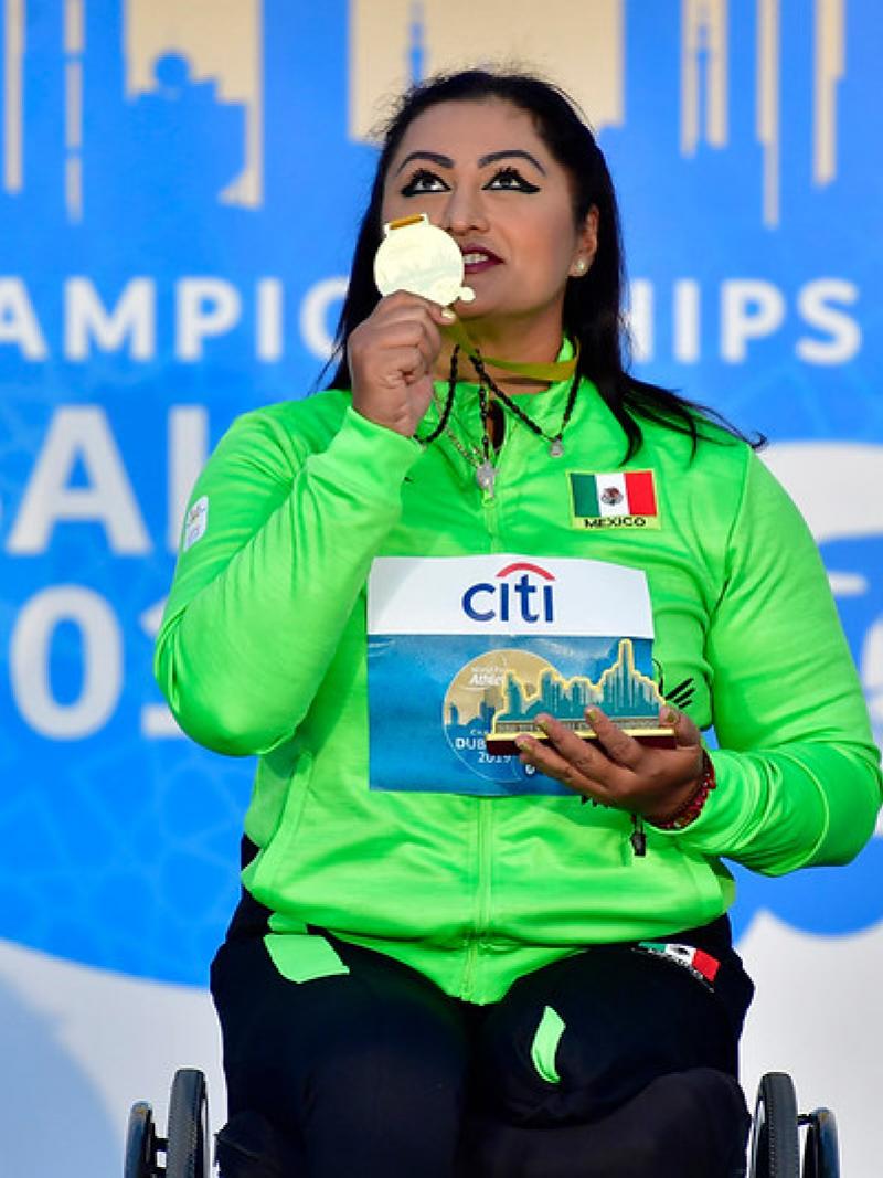 Image of a female Para Athletics in the podium with her gold medal