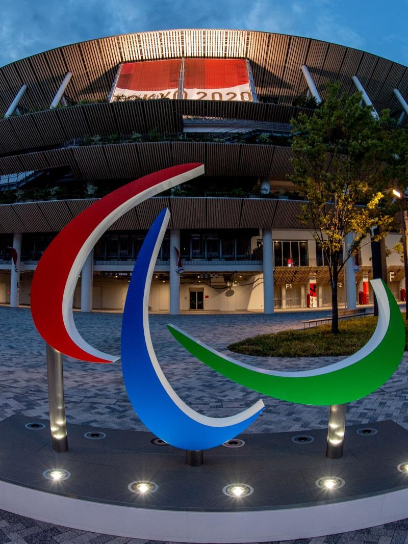 The Agitos sign in front of the Tokyo Stadium at dusk.