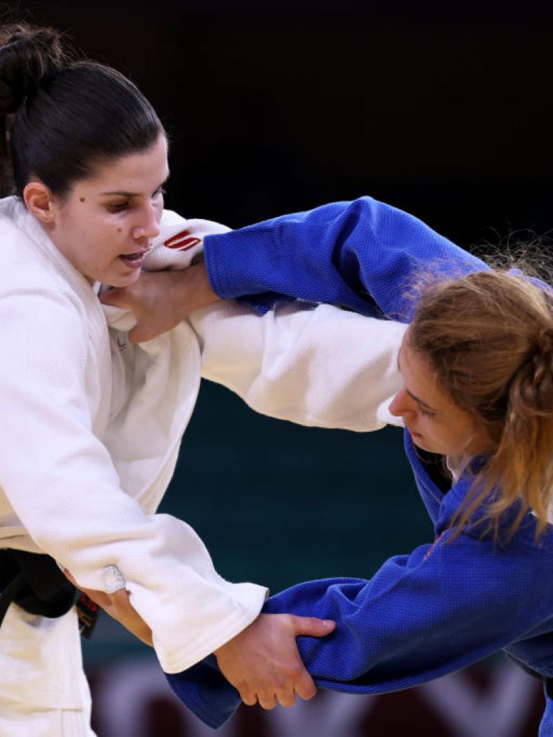 Two female judokas grapple in a competitive bout