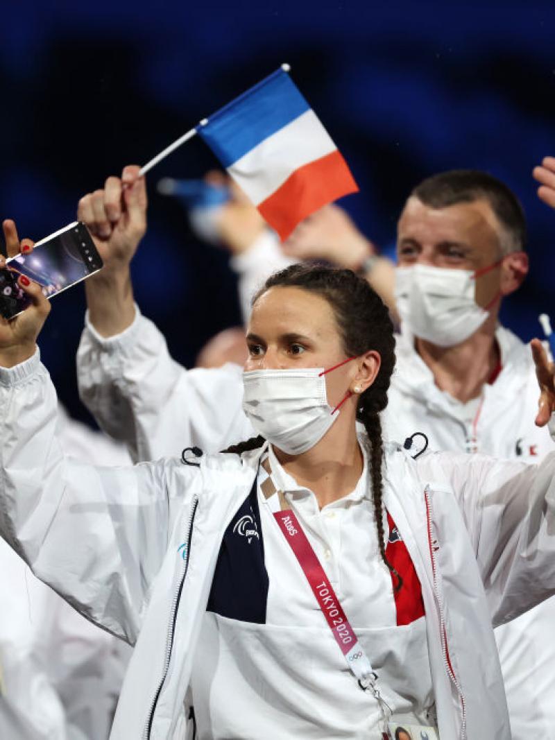 French athletes wave small flags during the athletes' parade at the Tokyo 2020 Opening Ceremony.
