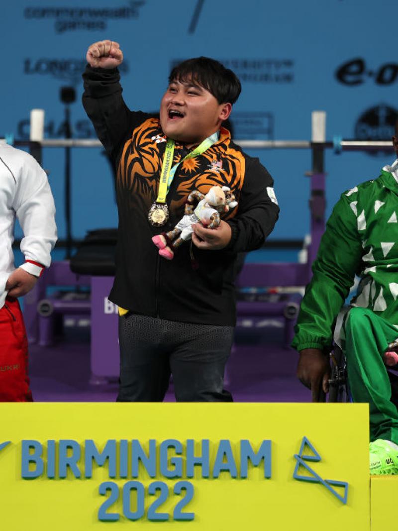 Malaysia's Bonnie Bunyau Gustin celebrates his gold medal on the podium.