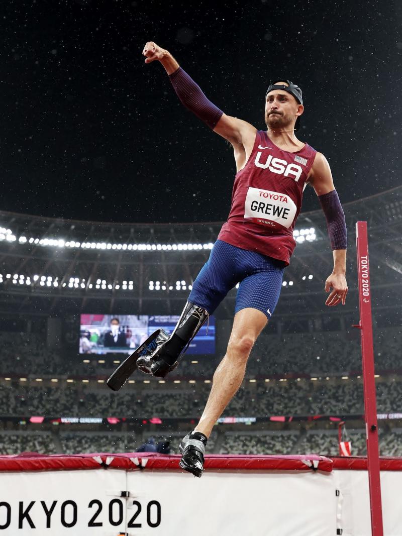 A male high jumper raises his right fist in celebration after winning his event at the Tokyo 2020 Paralympic Games.