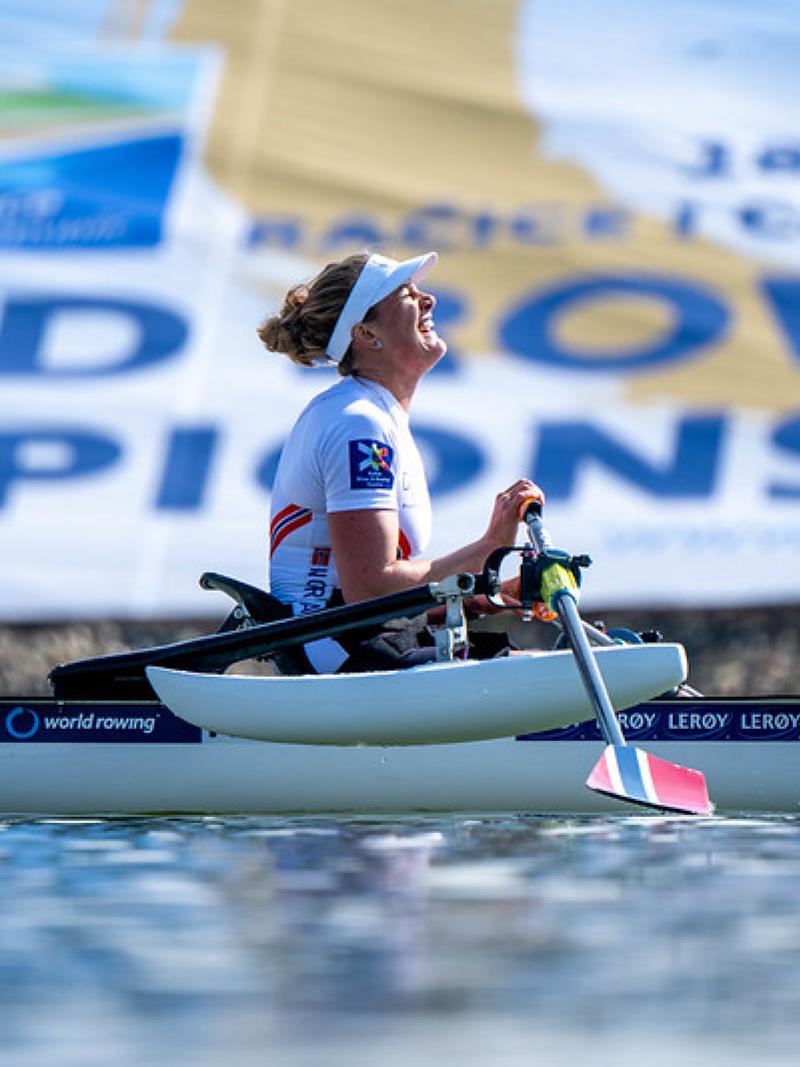 A side view of a female athlete on a rowing boat.