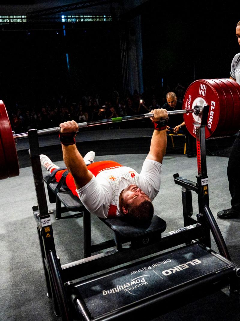 A heavyweight powerlifter prepares to make a lift with the audience watching on.