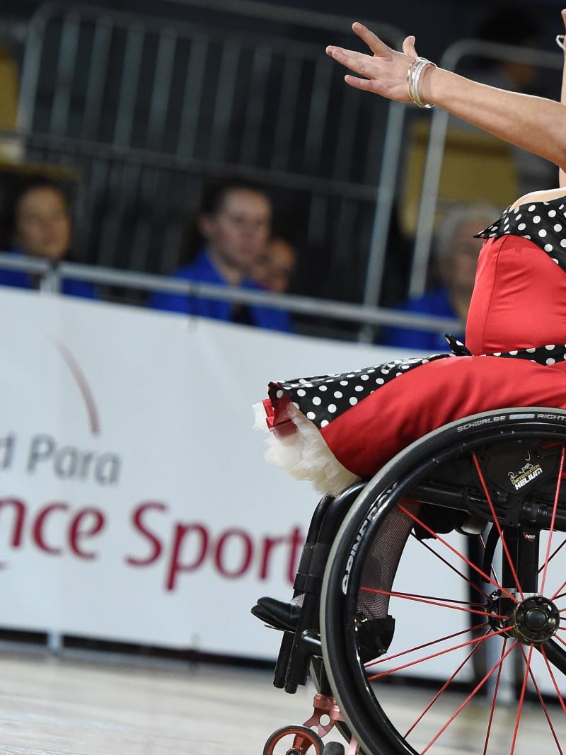 A female wheelchair dancer with a red dress during a competition