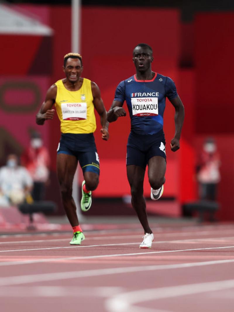 Four men running on an athletics track