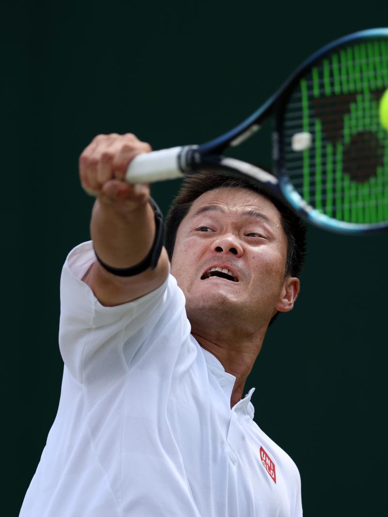 A closeup of a male tennis player as he plays a backhand during a wheelchair tennis tournament.