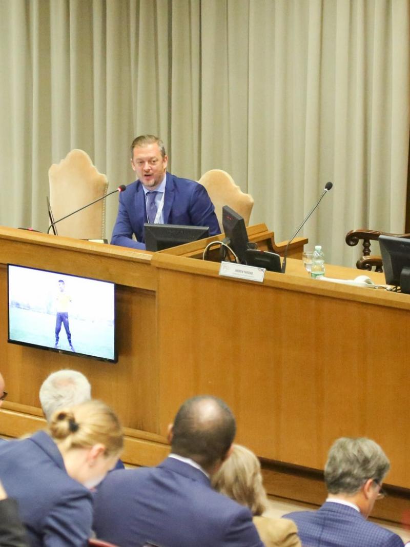 IPC President Andrew Parsons speaks in front of many participants at an international summit