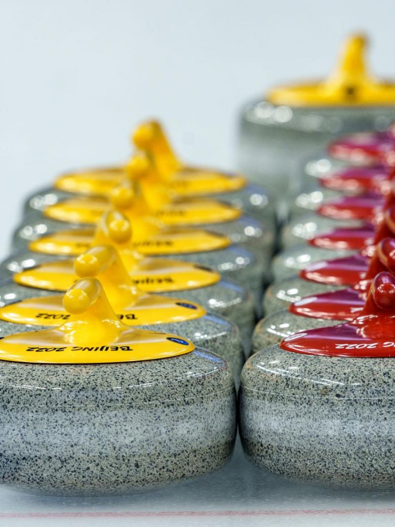 Two rows of Beijing 2022 curling stones marked on the ice.