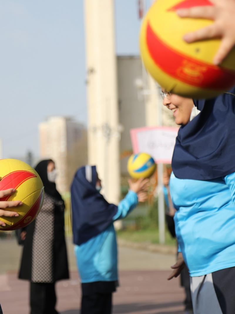 Teenage girls toss a ball as part of National Paralympic Day activities.