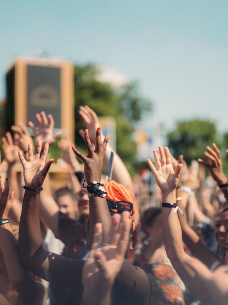 People in a large crowd raise their hands during the Paris 2024 handover celebration.