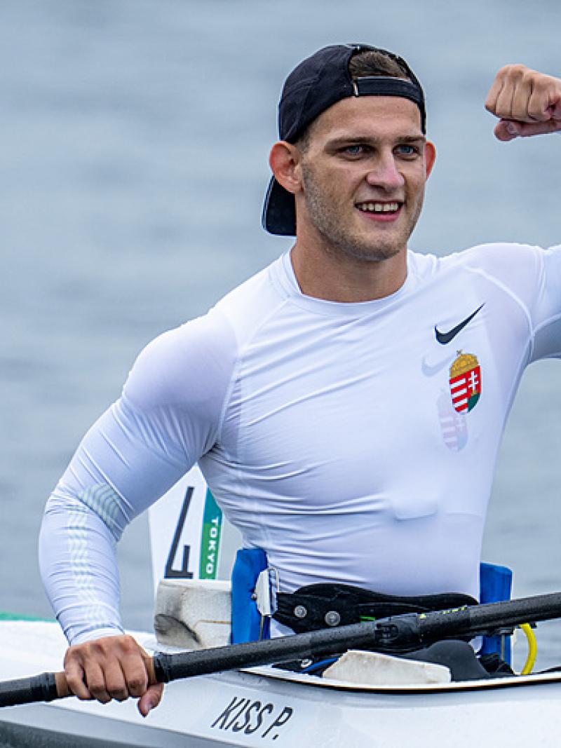 A male athlete in a kayak pumps his fist