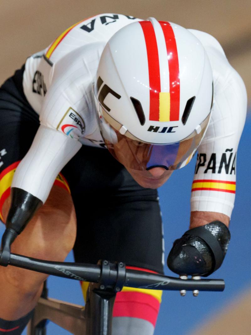 A male athlete wearing a helmet rides a bicycle at the Tokyo 2020 Paralympic Games.