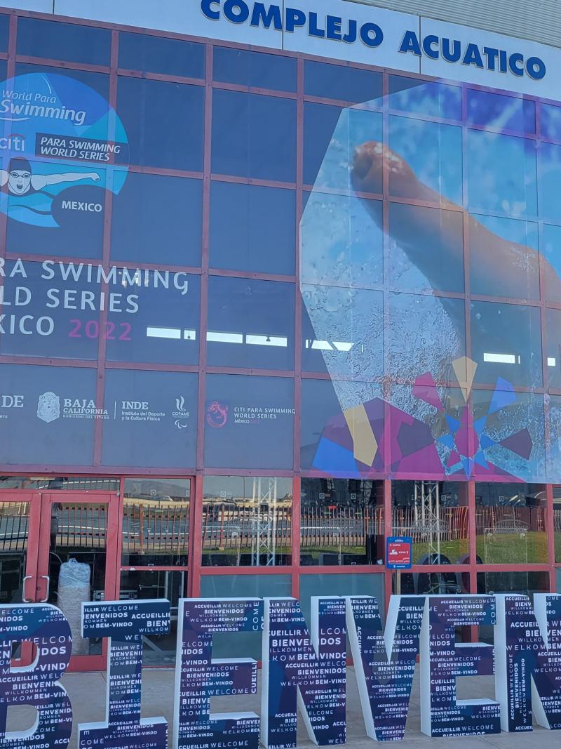 The entrance of an aquatics centre with the Bienvenidos message in front of the doors