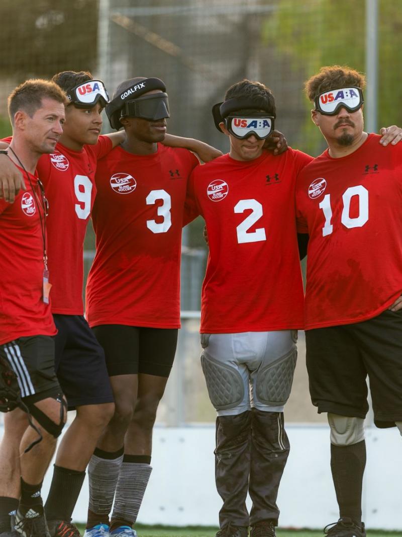 Five male athletes wearing a red T-shirt