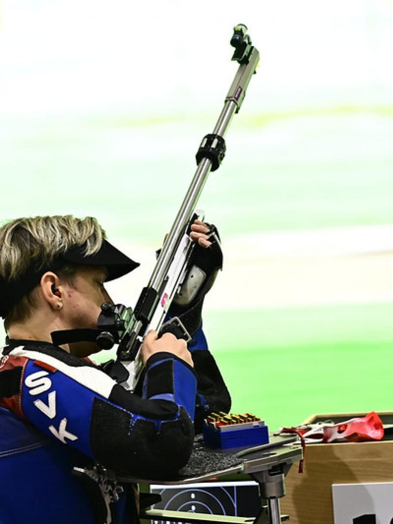A woman with a rifle in a shooting range during a shooting Para sport competition