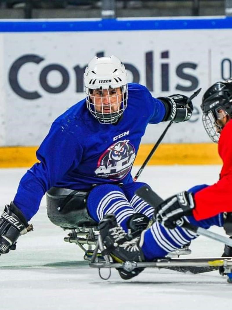 Two male Para ice hockey players competing on ice