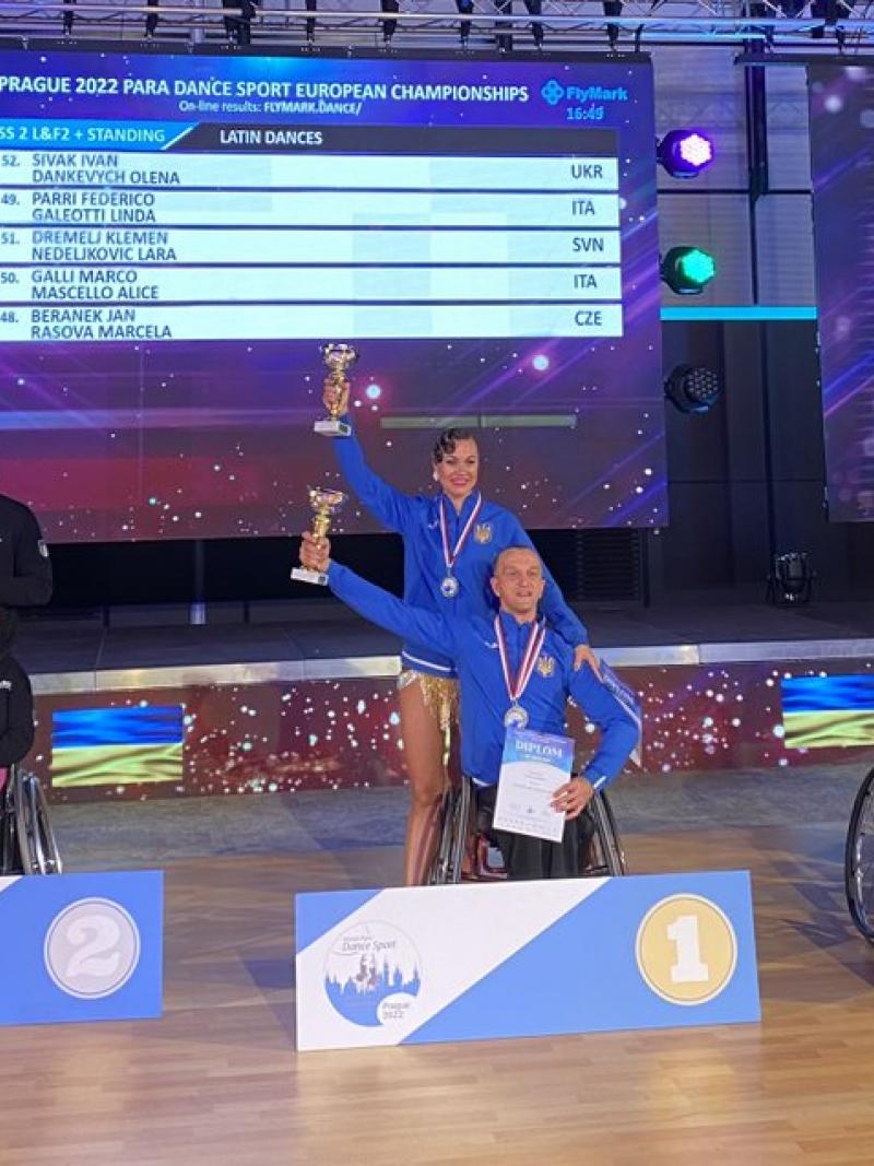 Ukraine's Ivan Sivak (centre) poses on the podium with his dance partner Olena Dankevych after taking the combi class 2 gold medal.