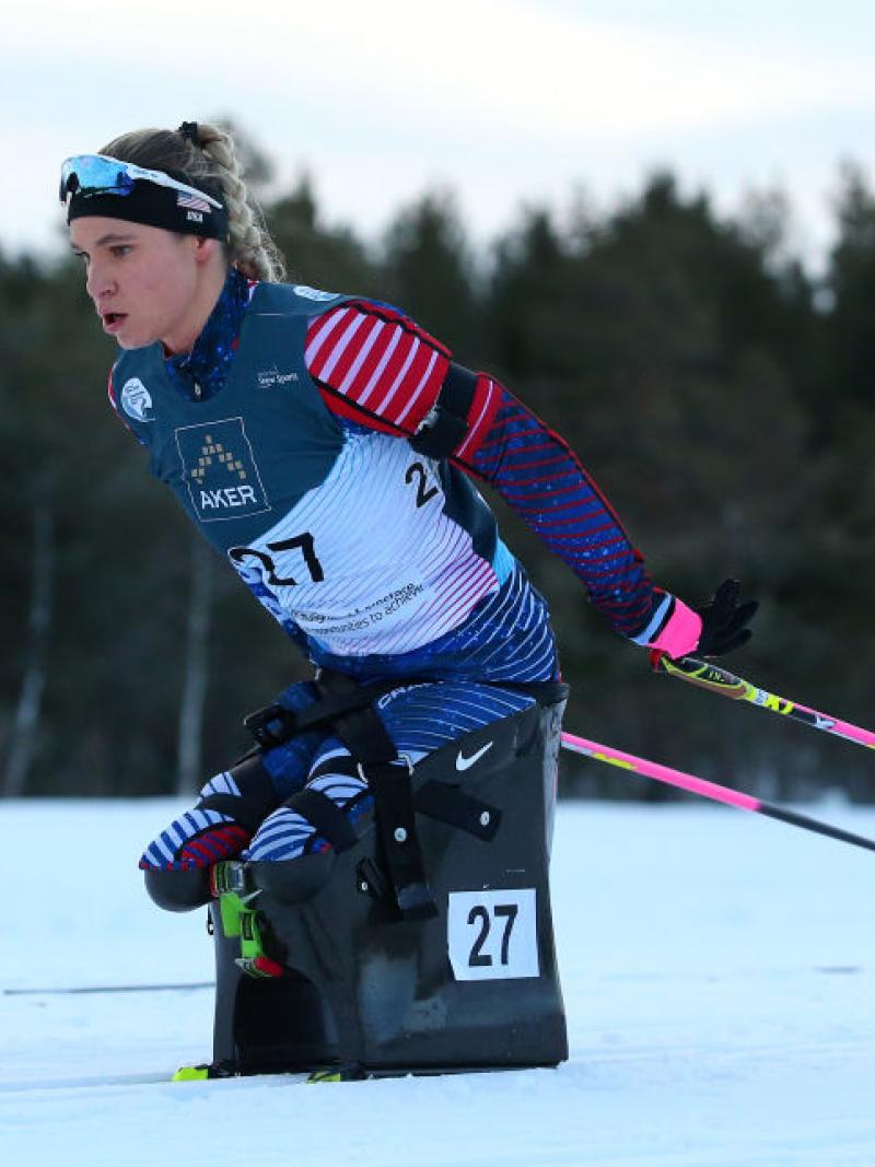 A female athlete on a sit-ski competes at the World Para Snow Sports Championships 