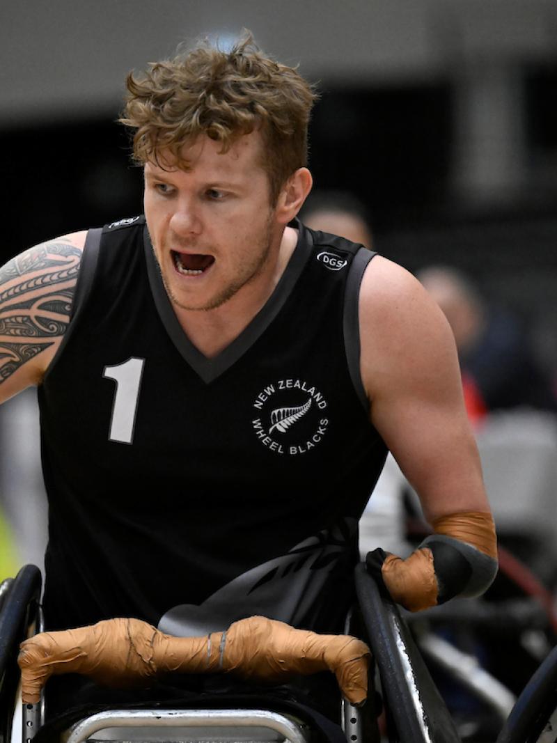 A male athlete wearing a black jersey competes at the 2022 Wheelchair Rugby World Championships