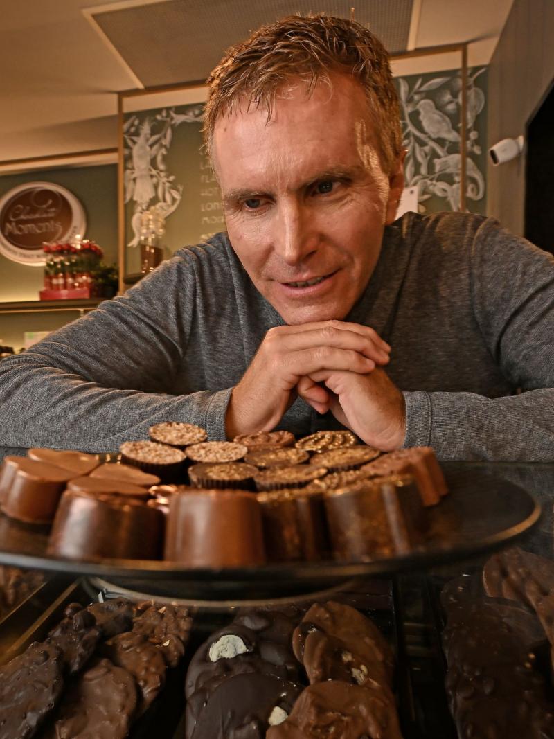 A man stands in front of a display of chocolates