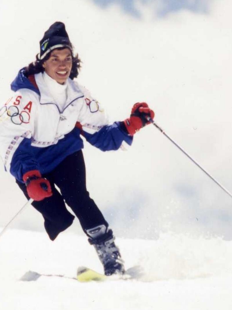 A female Alpine skier wearing a Team USA jacket skis