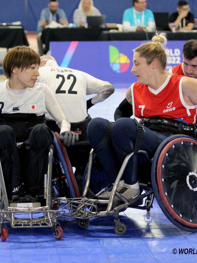 Two female wheelchair rugby players compete.