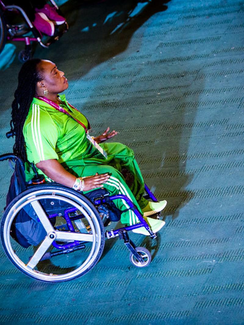 A woman in a wheelchair with a green Nigerian shirt