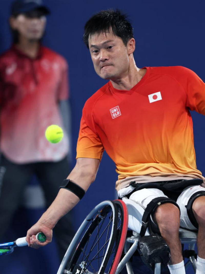 A male wheelchair tennis player prepares to hit a ball.