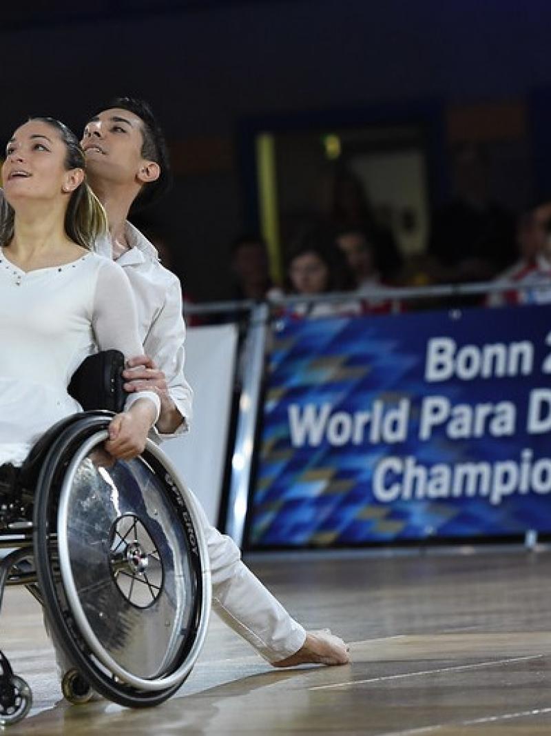 A woman in a wheelchair and a male partner in a dance competition