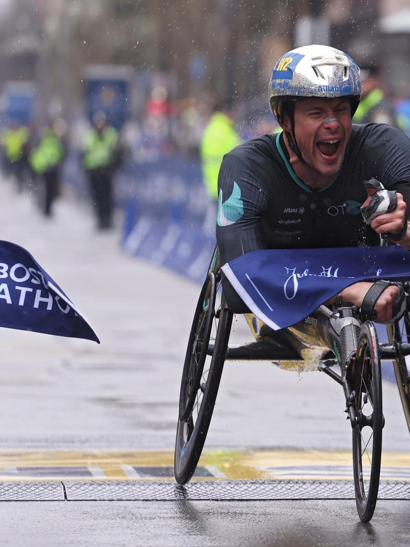 A male wheelchair racer crossing the finish line in a street marathon