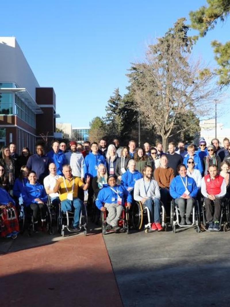 A group of about 80 people pose for a photograph.