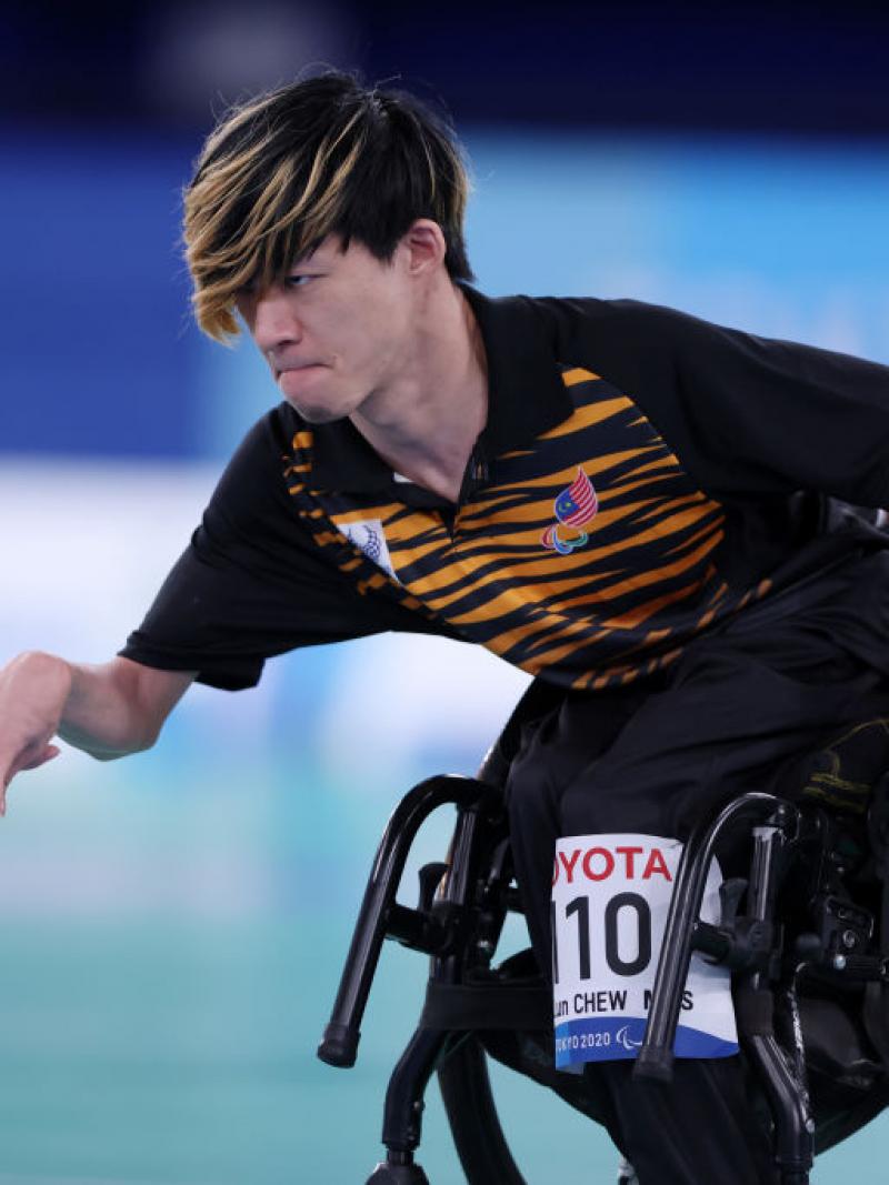A male boccia athlete throws a blue ball at the Tokyo 2020 Paralympic Games.