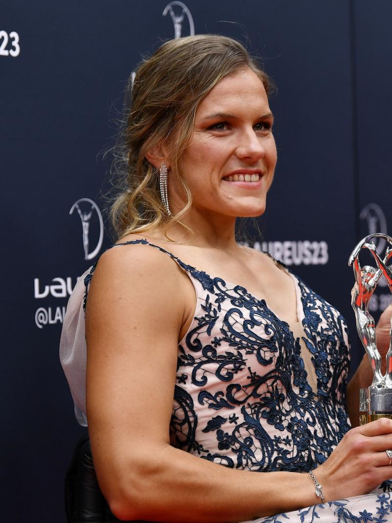A female athlete holds a silver trophy