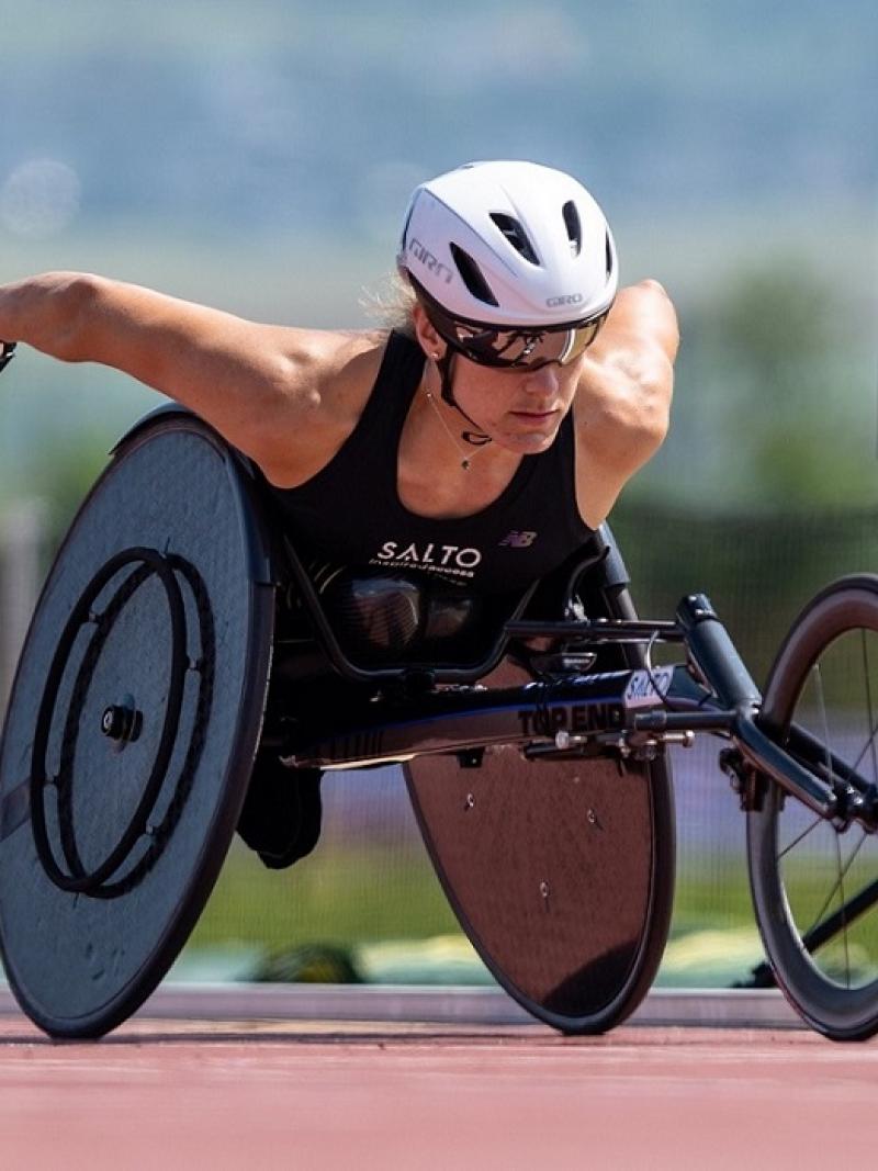 A female wheelchair racer on a red athletics track