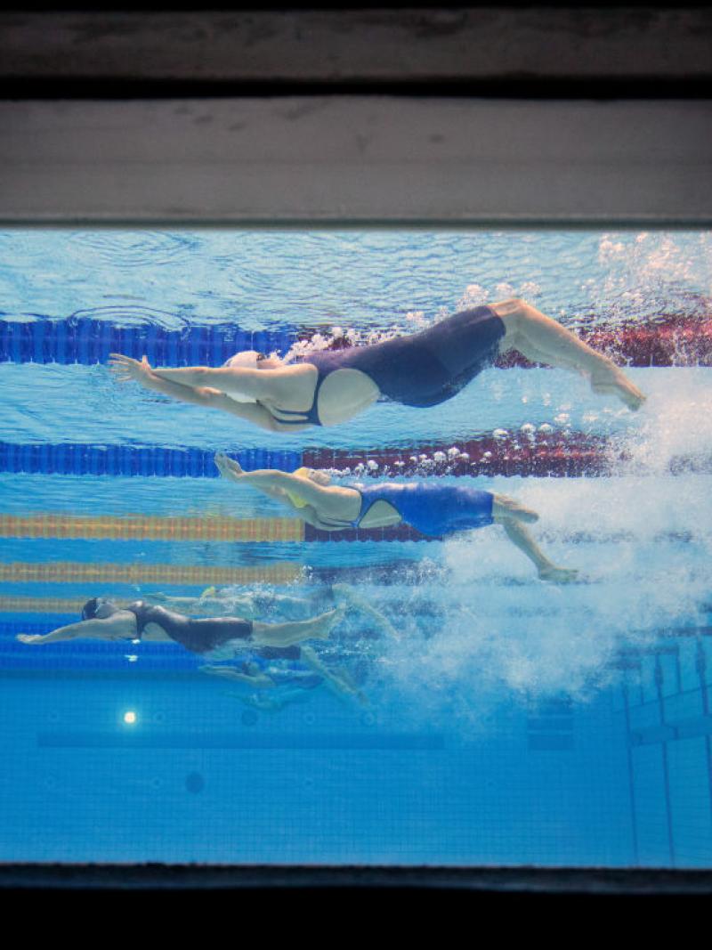 An image of three female Para swimmers from a window at the bottom of the pool